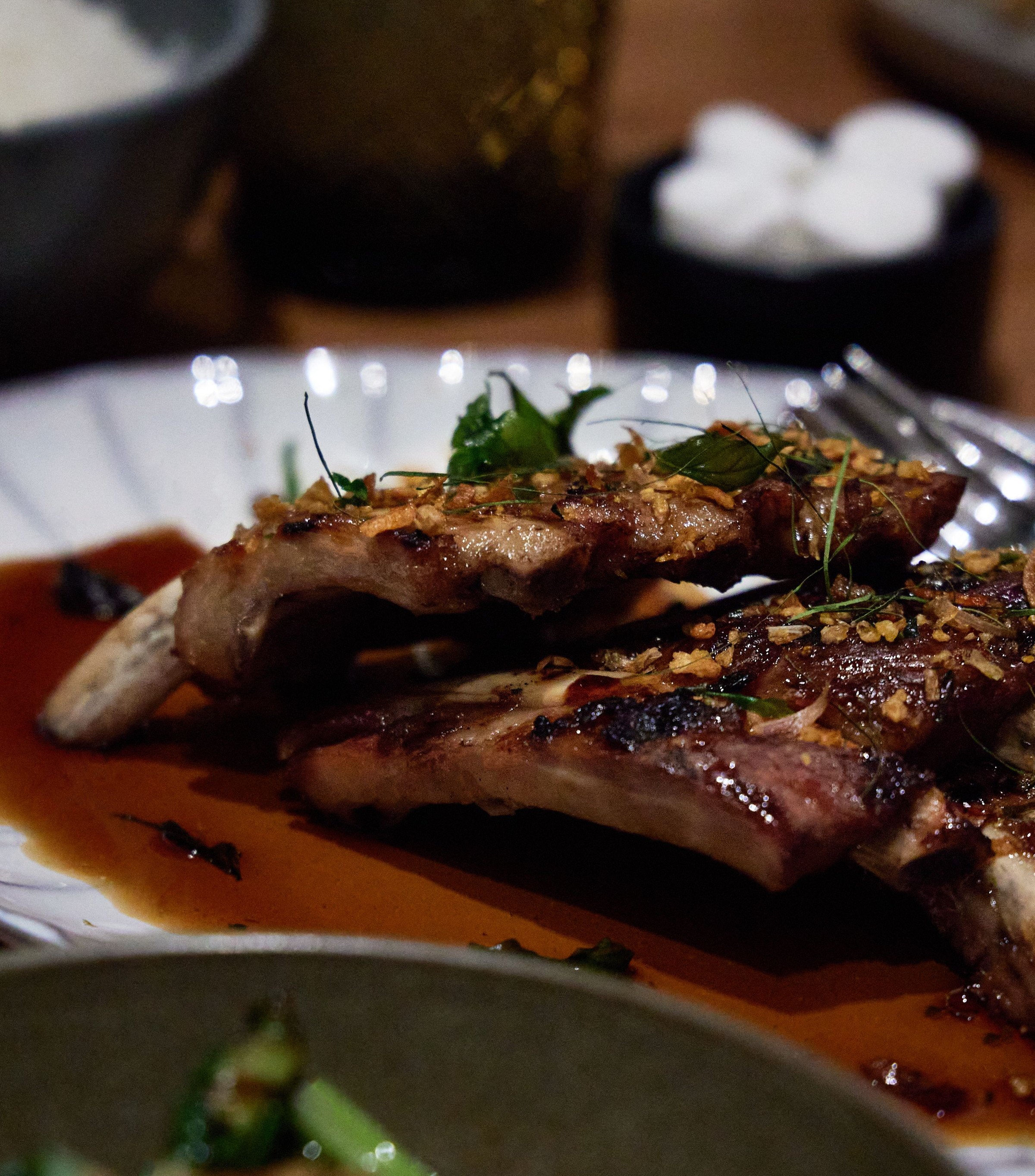 Illustrative stock photograph of glazed ribs in their sauce; restaurant presentation differs